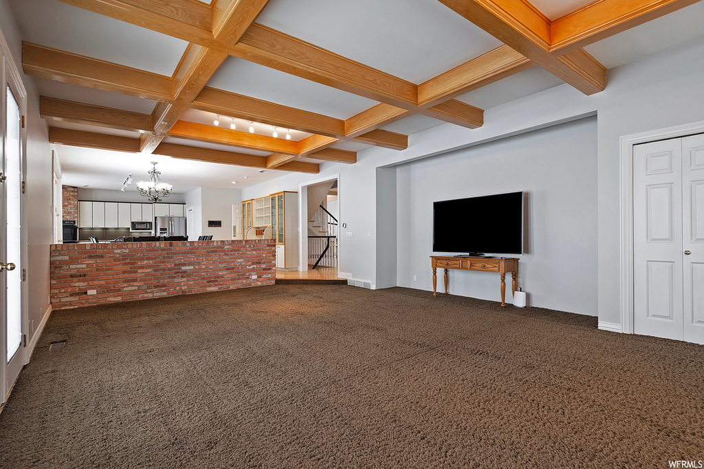Living room featuring coffered ceiling, beam ceiling, and carpet floors