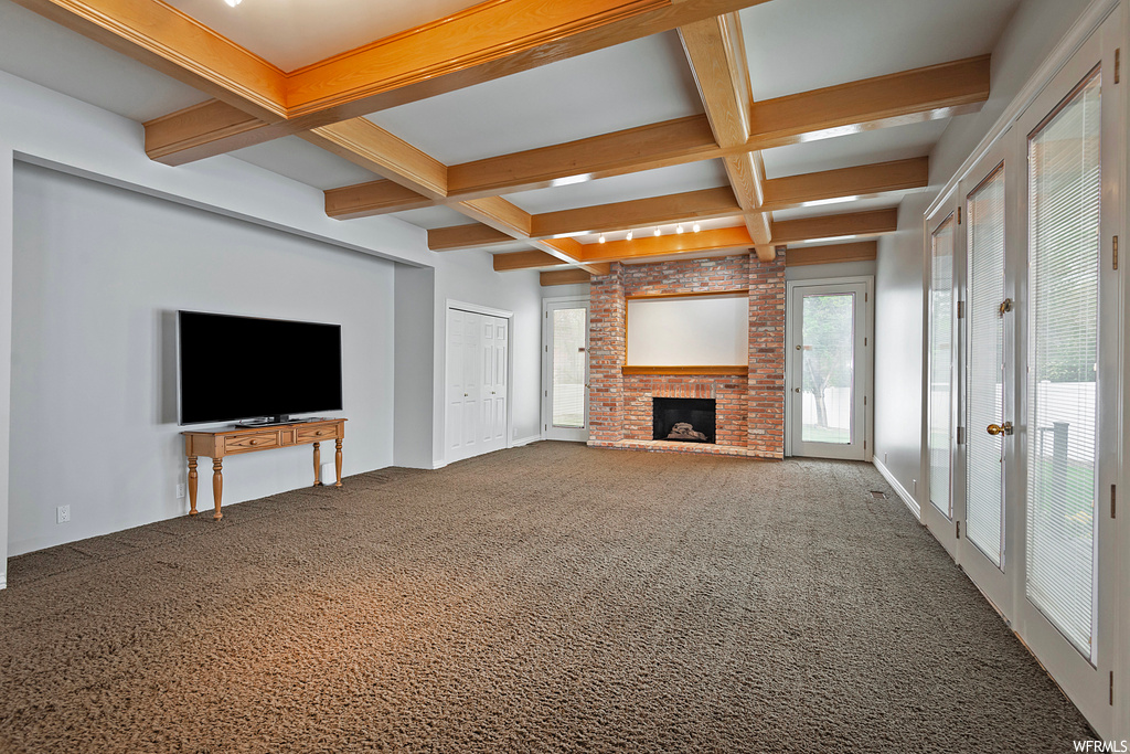 Living room featuring carpet, coffered ceiling, beamed ceiling, and a fireplace