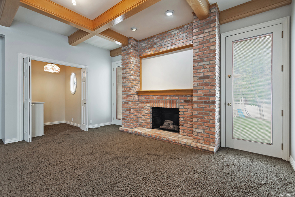 Carpeted living room featuring beam ceiling and a fireplace