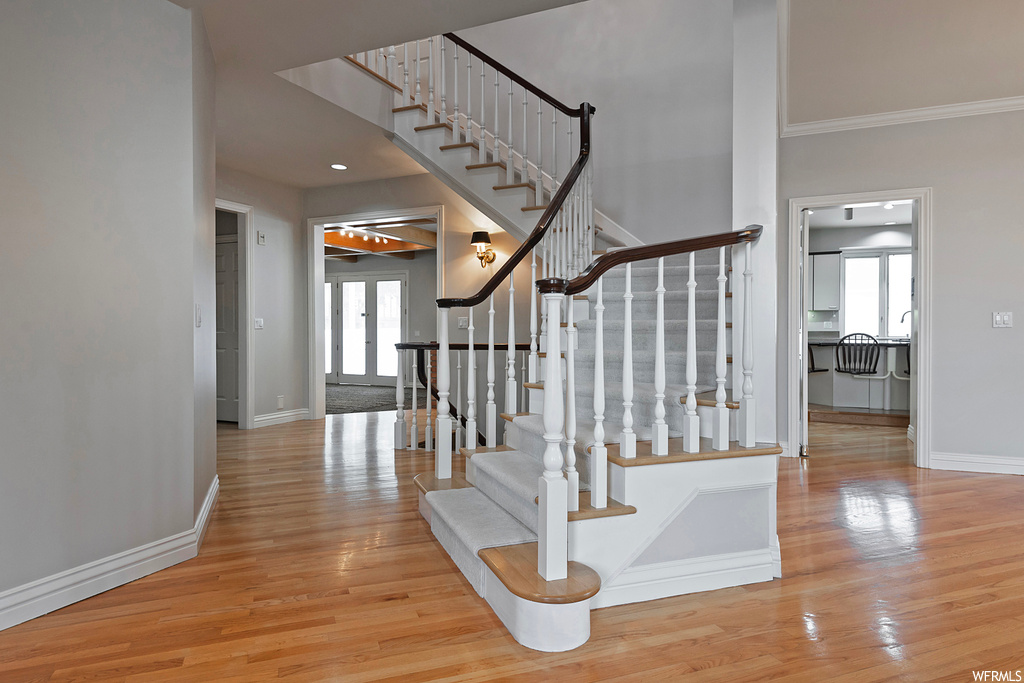 Stairway with ornamental molding and light hardwood floors