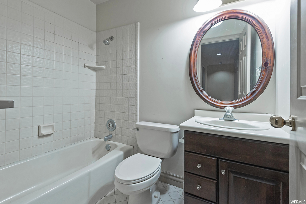 Full bathroom featuring tile floors, tiled shower / bath, vanity with extensive cabinet space, and mirror