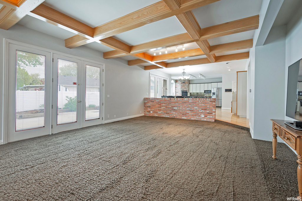 Living room with light carpet, coffered ceiling, and beam ceiling