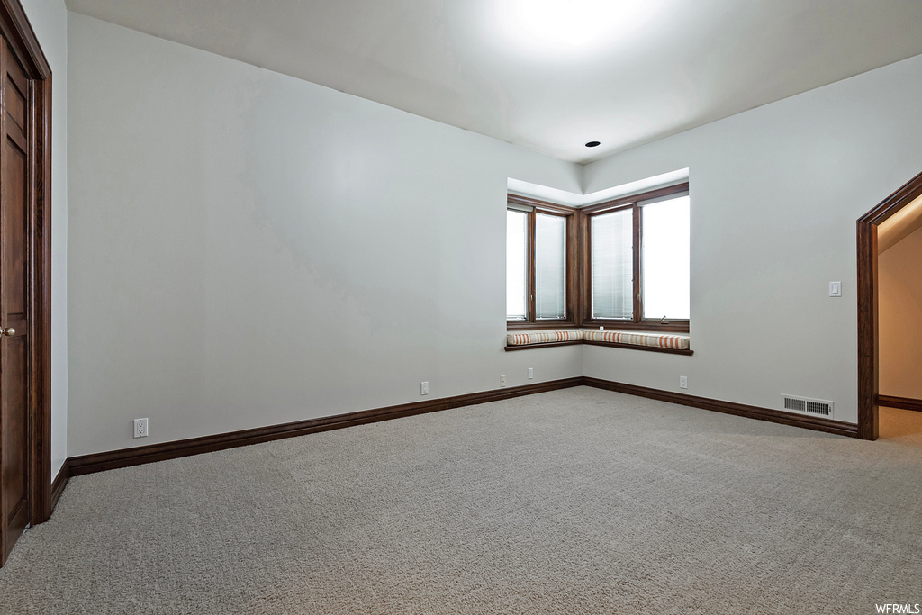 Empty room featuring light carpet