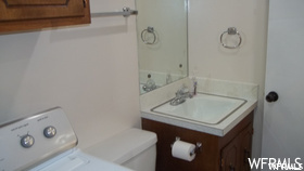Bathroom with large vanity, mirror, and washer / dryer