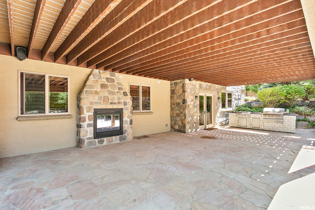 View of terrace featuring an outdoor fireplace and an outdoor kitchen