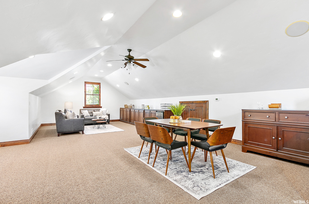 Dining room featuring light carpet and vaulted ceiling
