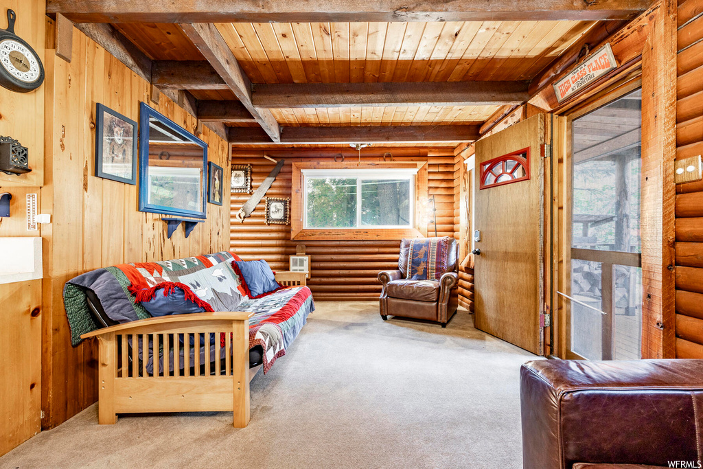 Carpeted living room featuring log walls, wood ceiling, and beam ceiling