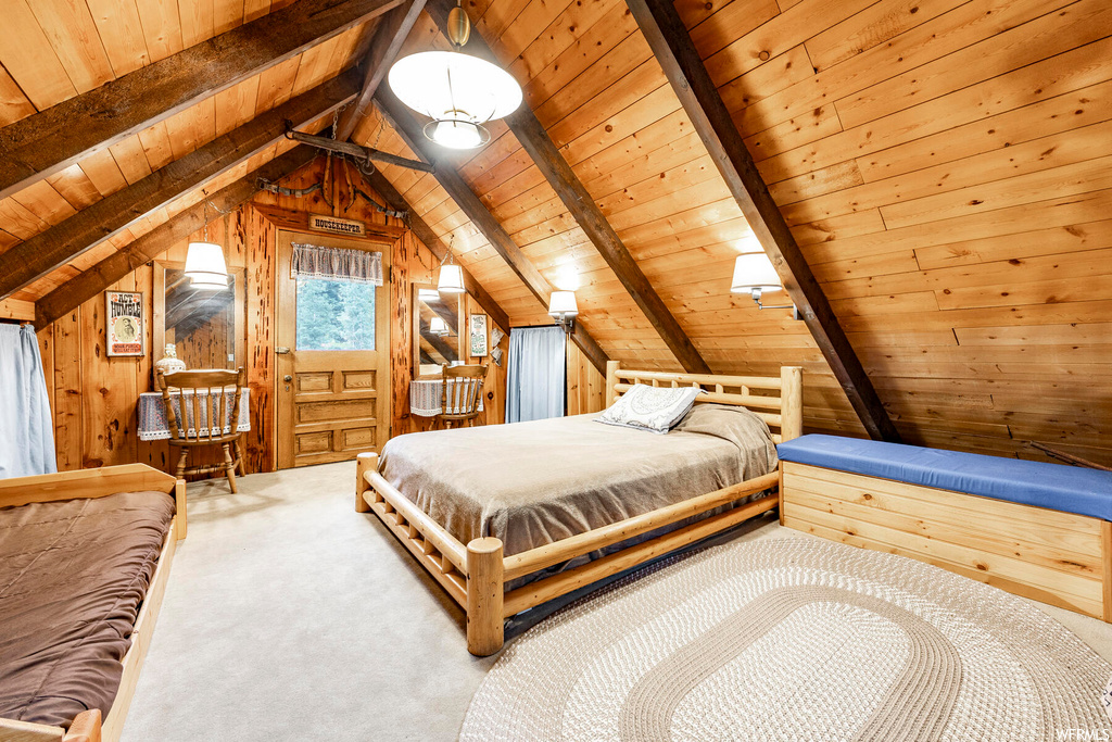 Bedroom with wood ceiling, wooden walls, vaulted ceiling with beams, and light carpet