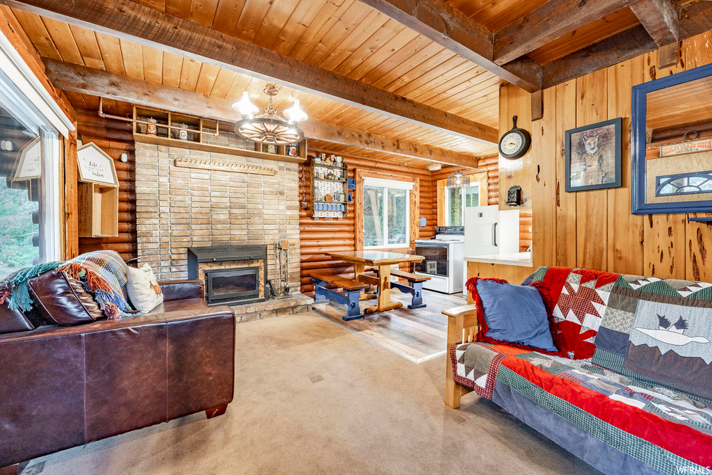 Living room featuring brick wall, log walls, a fireplace, light carpet, wood ceiling, and beam ceiling