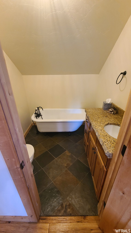 Bathroom with tile flooring, vanity, and a bathing tub