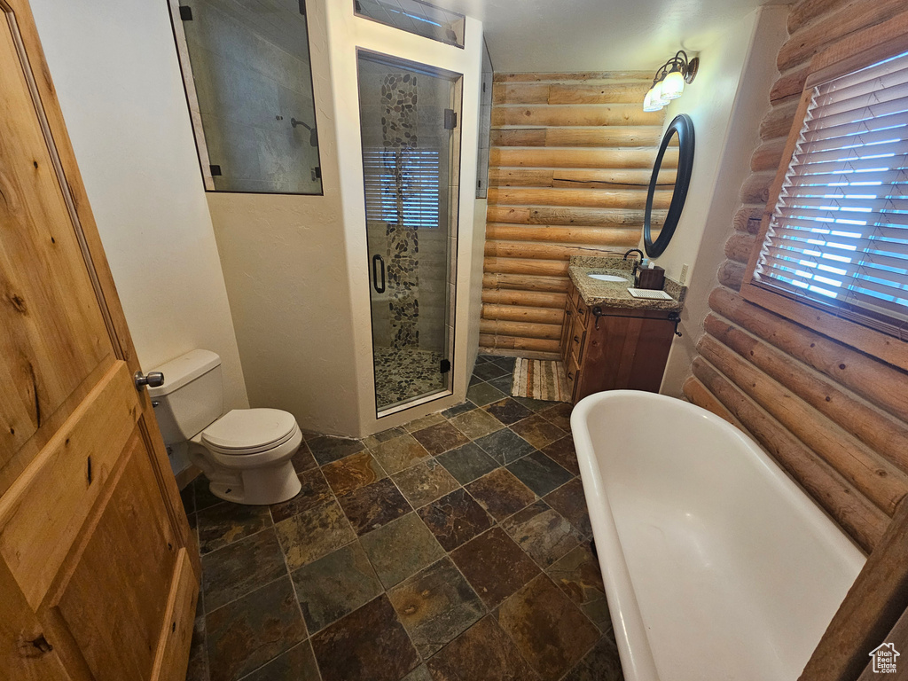 Full bathroom featuring log walls, vanity, toilet, tile flooring, and shower with separate bathtub