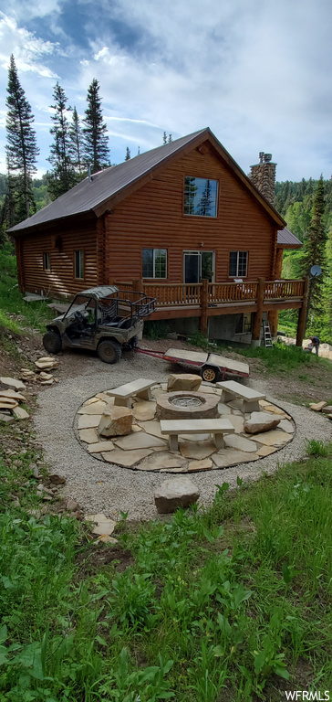 Back of house with a firepit and wooden deck