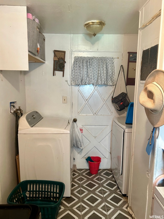 Clothes washing area with washing machine and dryer and light tile floors