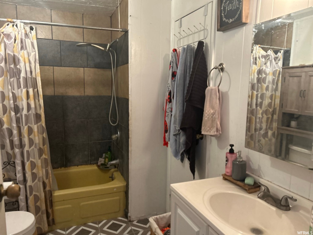 Full bathroom featuring shower / bathtub combination with curtain, mirror, and vanity
