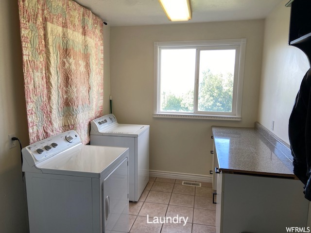 Laundry area with washing machine and clothes dryer and light tile floors