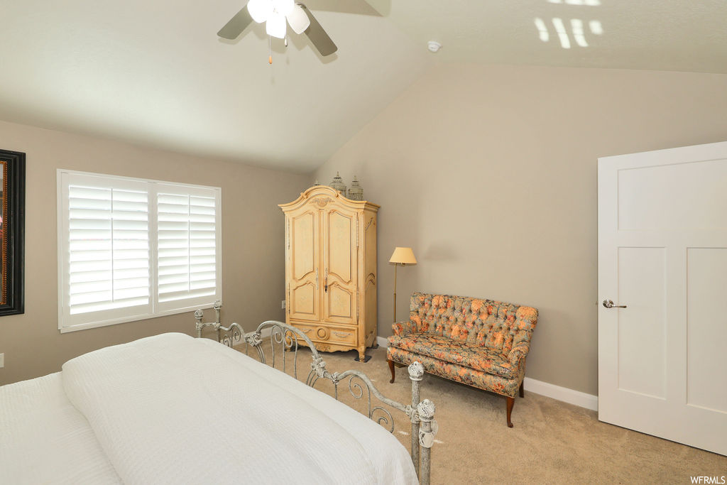 Bedroom featuring light carpet, lofted ceiling, and ceiling fan