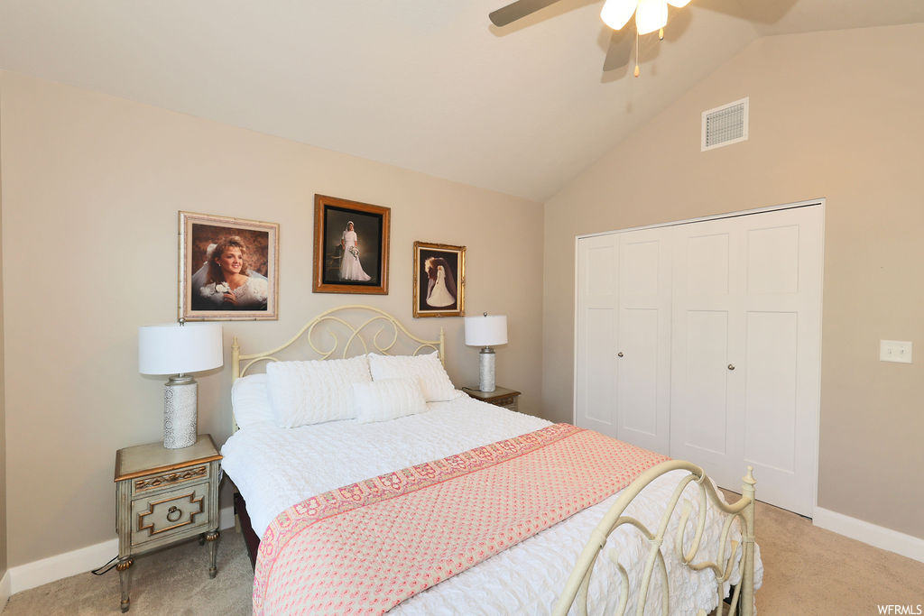 Bedroom with vaulted ceiling, light carpet, and ceiling fan