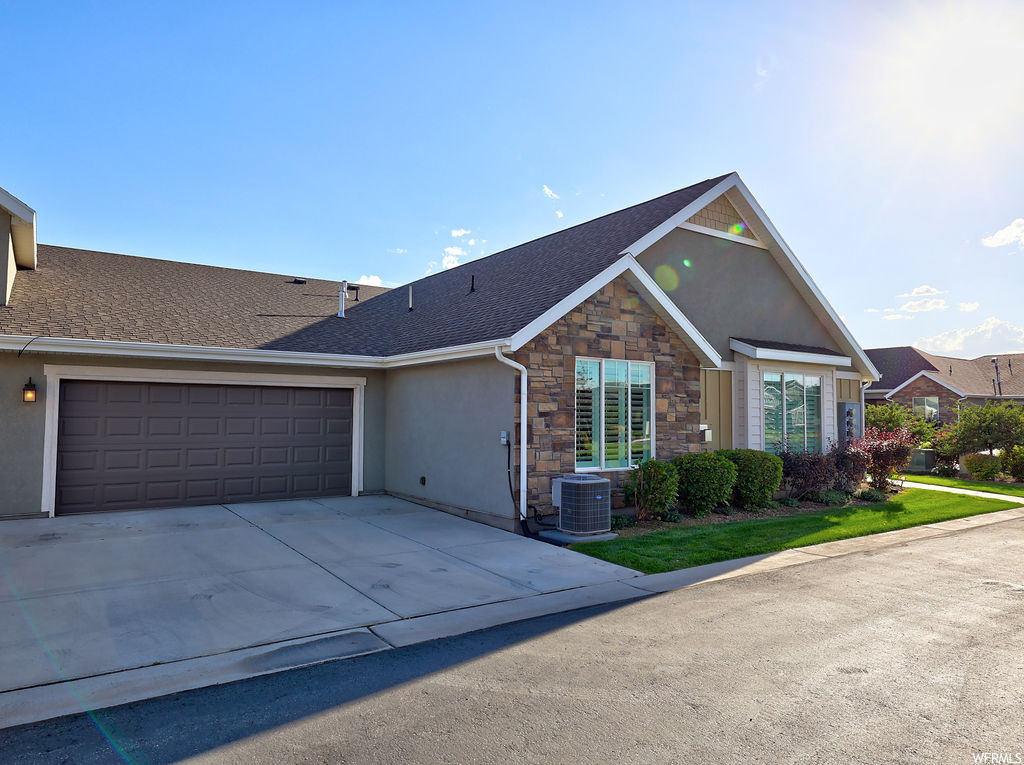Ranch-style house featuring garage and central AC unit