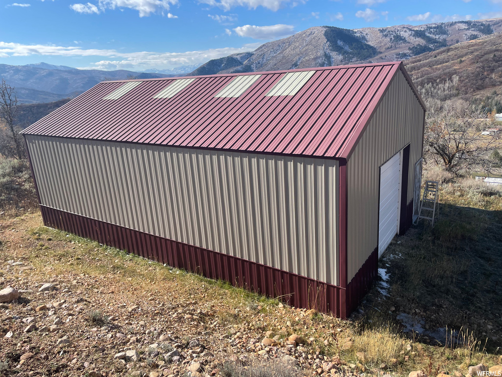 View of shed / structure featuring a mountain view, a garage, and central AC unit