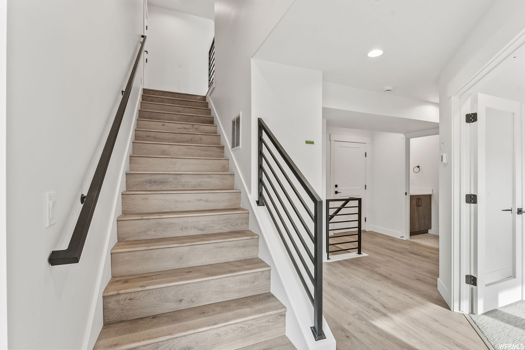 Stairway featuring light hardwood / wood-style flooring
