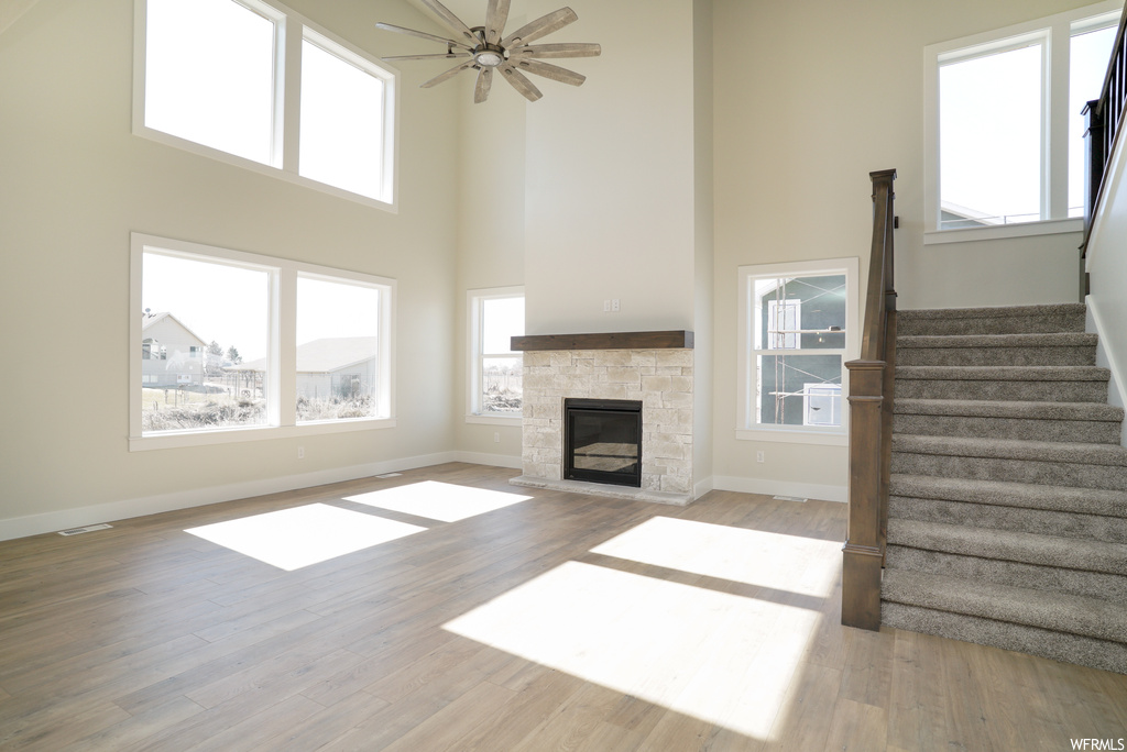 Living room featuring a high ceiling, light hardwood floors, and a healthy amount of sunlight