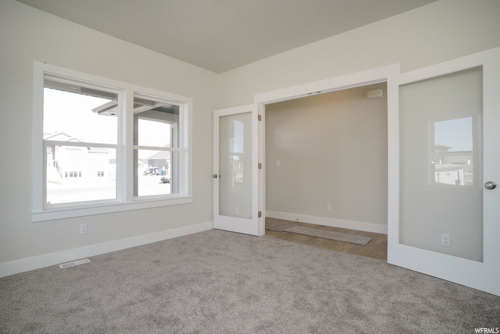 Hardwood floored bedroom featuring multiple windows