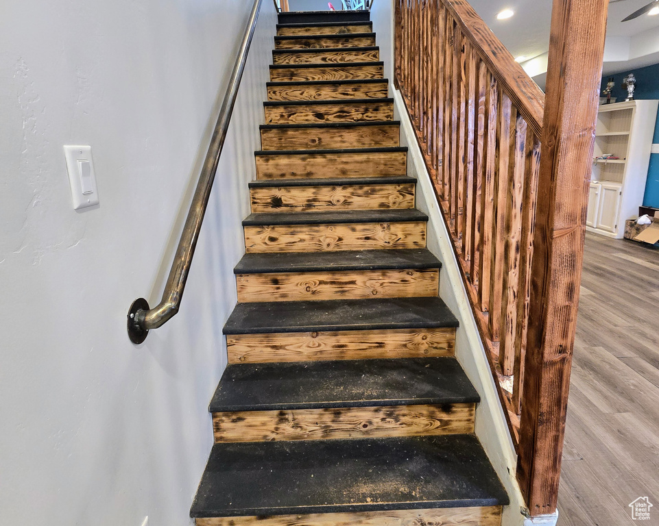 Staircase featuring hardwood / wood-style flooring