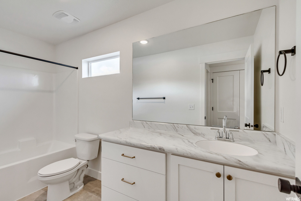 Full bathroom featuring shower / tub combination, vanity with extensive cabinet space, light tile flooring, and mirror
