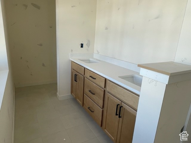 Bathroom featuring dual sinks and tile flooring