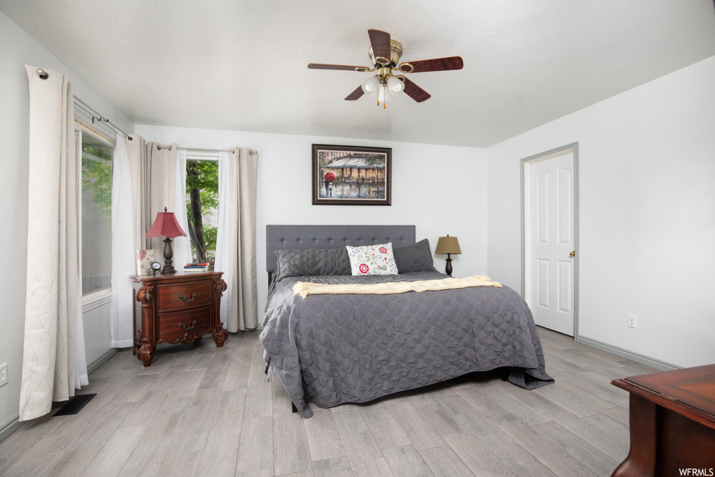 Hardwood floored bedroom featuring ceiling fan