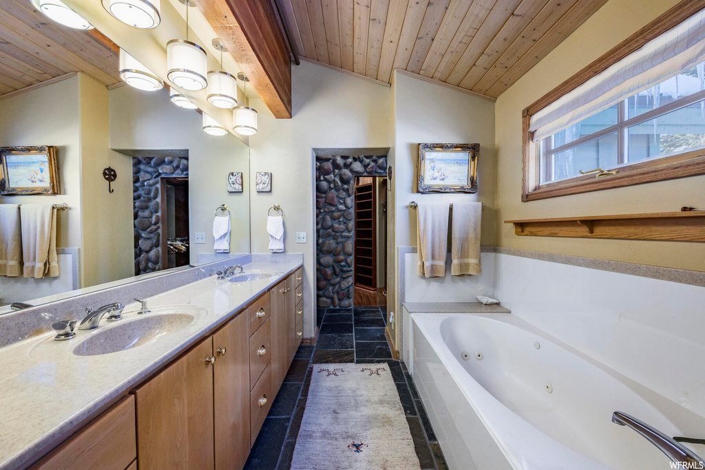 Bathroom featuring a washtub, mirror, light tile floors, wooden ceiling, lofted ceiling, and dual bowl vanity