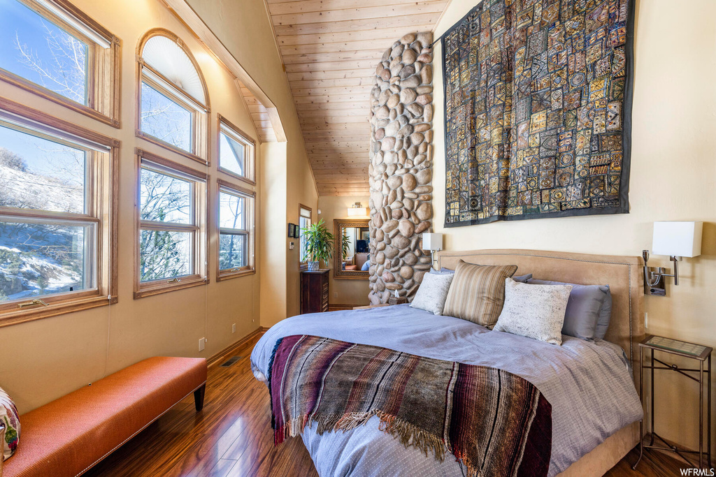 Bedroom featuring light hardwood flooring, vaulted ceiling, a high ceiling, and wooden ceiling