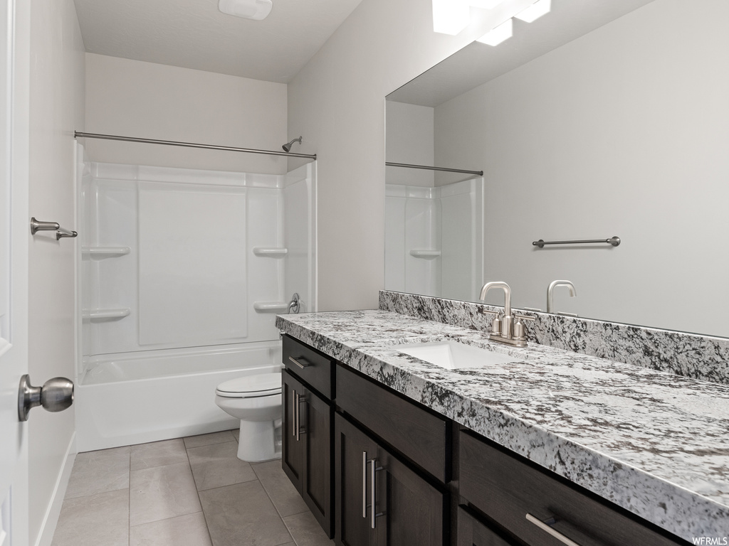 Full bathroom featuring vanity with extensive cabinet space, bathing tub / shower combination, mirror, and light tile floors
