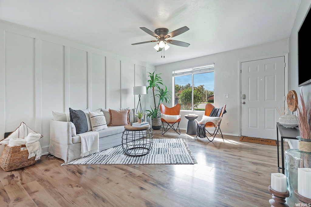 Living room with light hardwood floors and ceiling fan