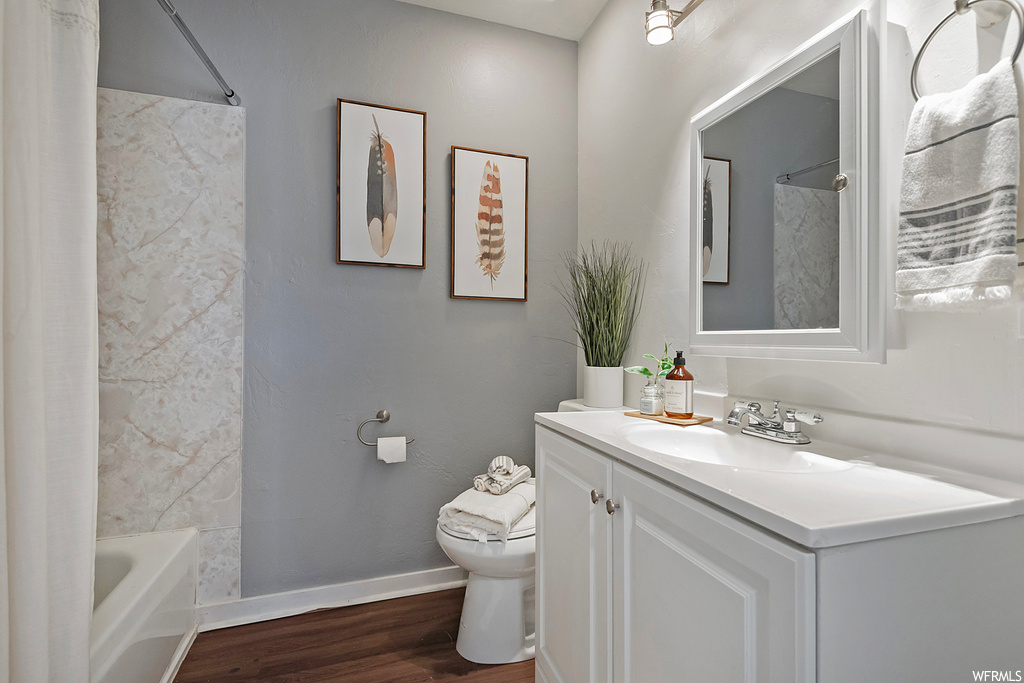 Full bathroom featuring hardwood flooring, tiled shower / bath combo, mirror, and vanity