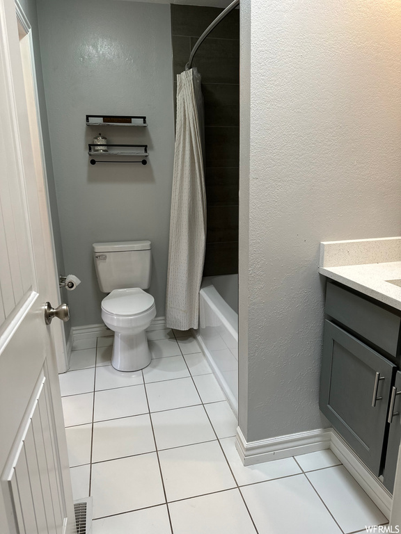 Full bathroom featuring vanity, shower / bath combo, and light tile floors