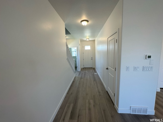 Hallway with dark hardwood flooring