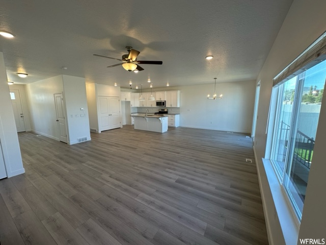 Living room with light hardwood flooring and ceiling fan