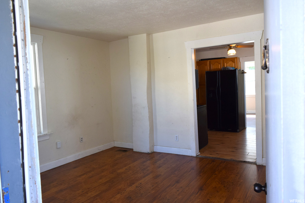 Unfurnished room with dark hardwood floors and a textured ceiling