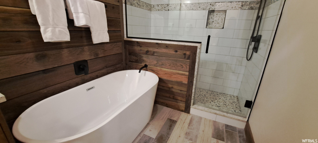 Bathroom featuring separate shower and tub and wood-type flooring