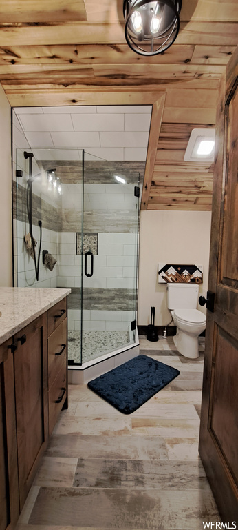 Bathroom with vanity, wood ceiling, a shower with shower door, and light hardwood flooring