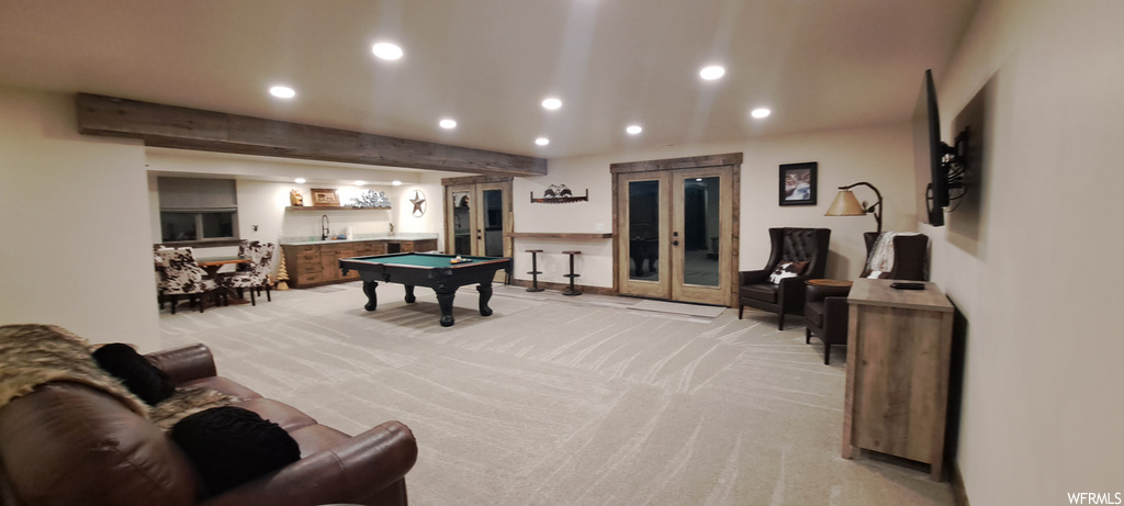 Game room featuring light carpet, french doors, and beam ceiling