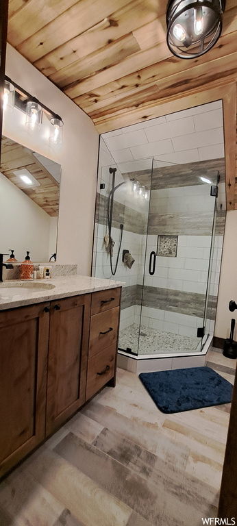 Bathroom with vanity, wooden ceiling, light hardwood floors, and a shower with door