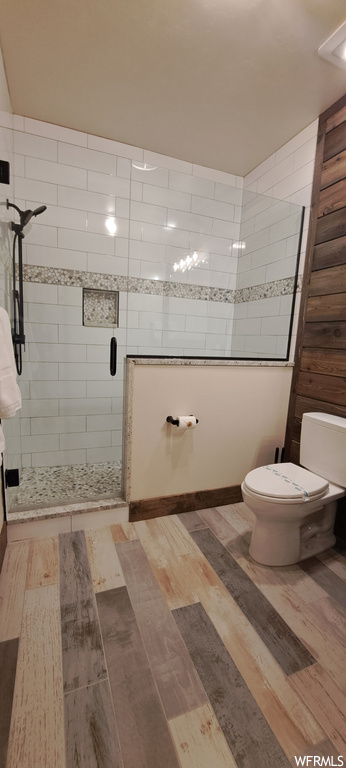 Bathroom with light hardwood flooring and a shower with door