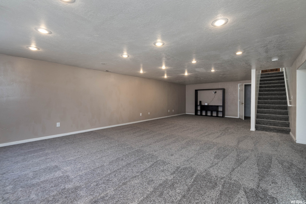 Basement with carpet flooring and a textured ceiling