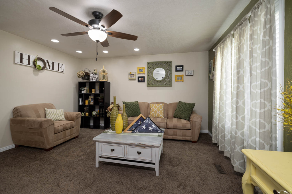 Living room featuring carpet and ceiling fan