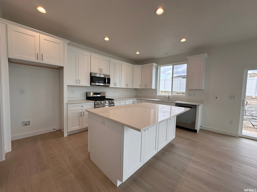 Kitchen featuring light hardwood / wood-style flooring, white cabinetry, and appliances with stainless steel finishes