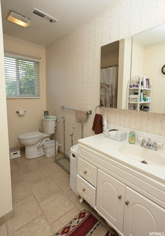 Bathroom with large vanity, mirror, and light tile flooring