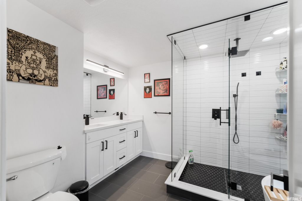 Bathroom featuring tile flooring, an enclosed shower, mirror, and vanity