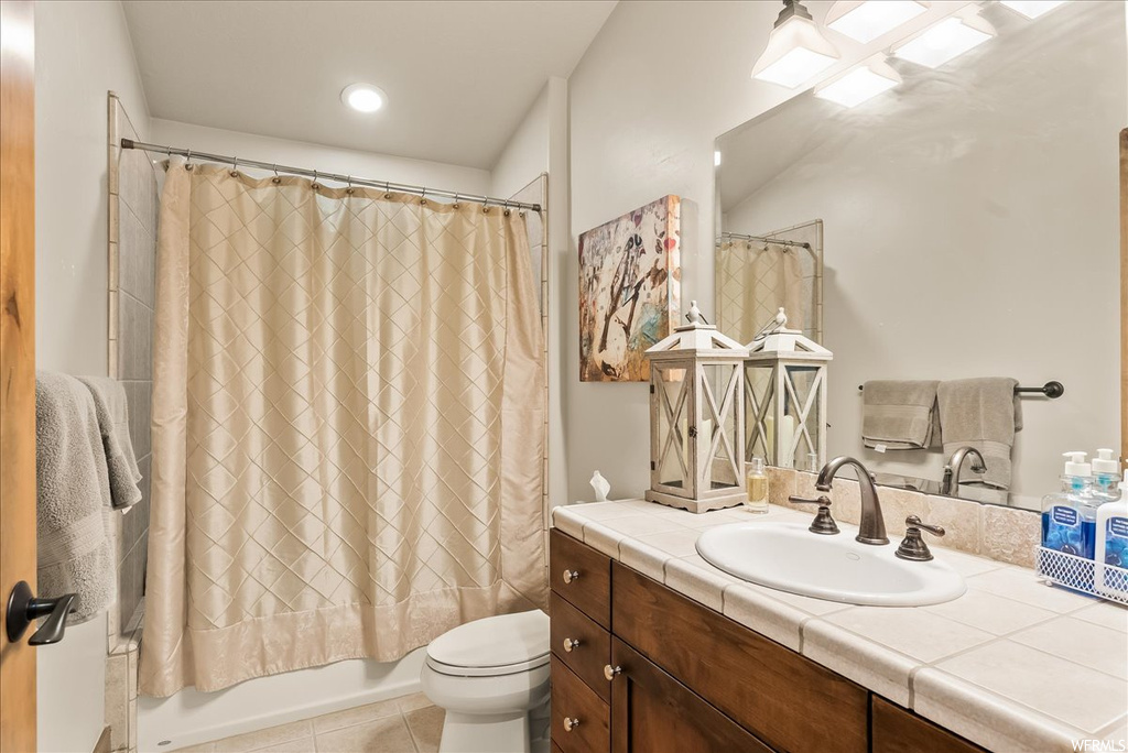 Full bathroom featuring vanity, mirror, shower / bathtub combination with curtain, and light tile floors